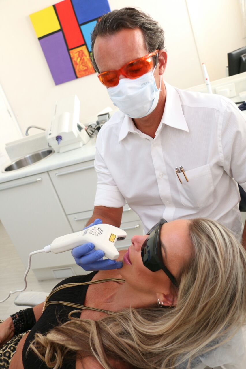 Dr. Marcelo Martins realizando atendimento com laser