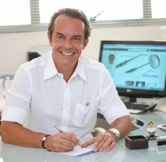 Dr. Marcelo Martins em sua mesa no consultório de Moema